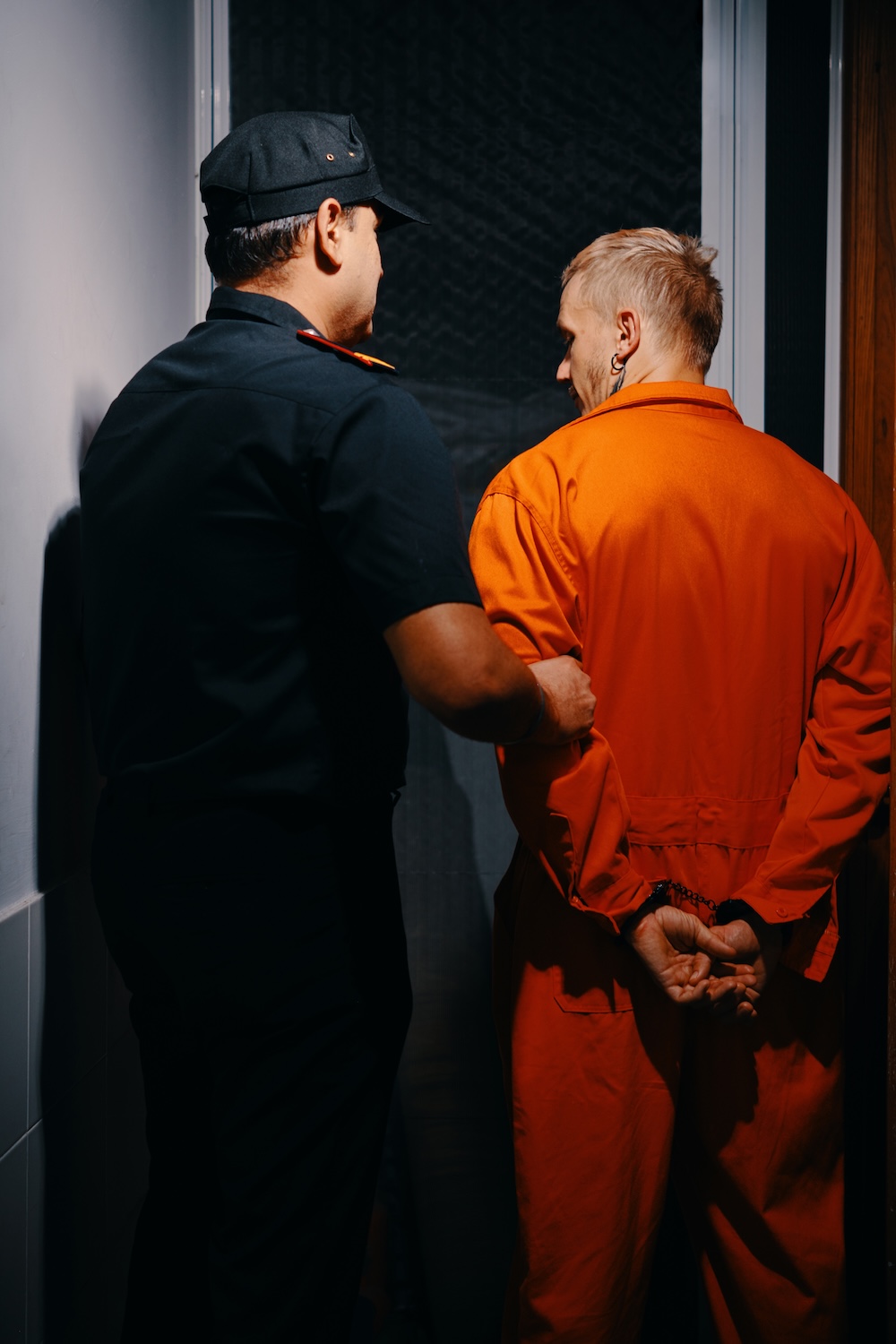guard walking a criminal downa hall for court